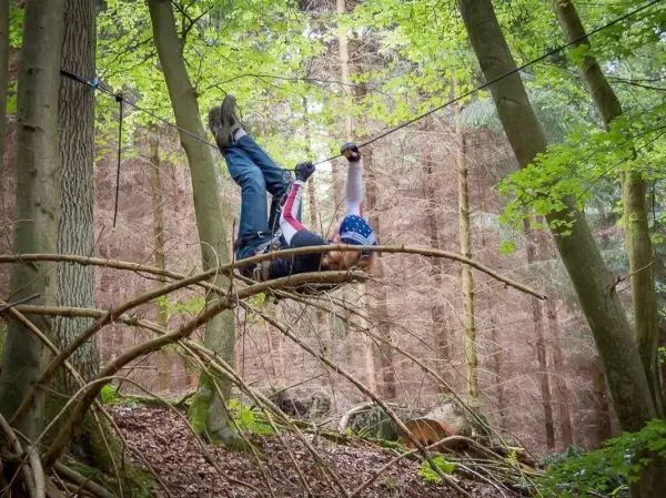 Selbstgebaute Seilquerung mit Person, die kopfüber hängt