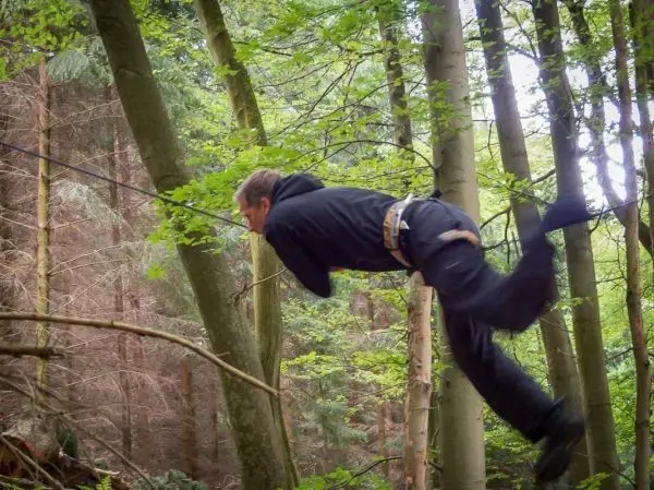 Selbstgebaute Seilquerung wird zwischen zwei Bäumen überquert