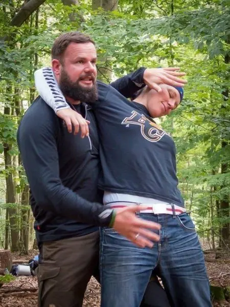 Zwei Personen demonstrieren eine Selbstverteidigungstechnik im Wald