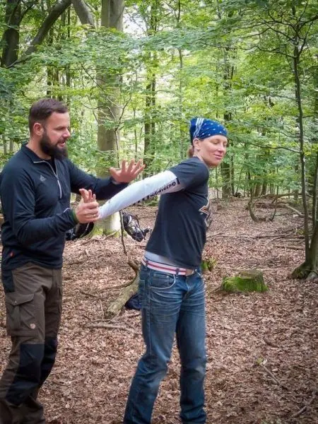 Zwei Personen üben eine Technik zur Handbefreiung im Wald