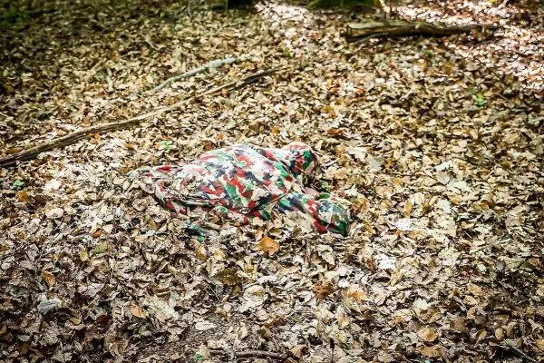 Camouflage-Muster liegt auf Laubboden im Wald