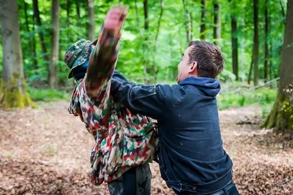 Kampftraining mit zwei Personen im Wald, eine Person greift die andere an