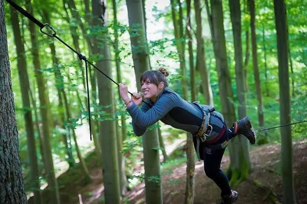 Selbstgebaute Seilquerung wird zwischen Bäumen überquert
