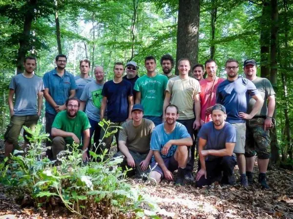 Gruppierung von Personen im Wald, umgeben von Bäumen und Pflanzen