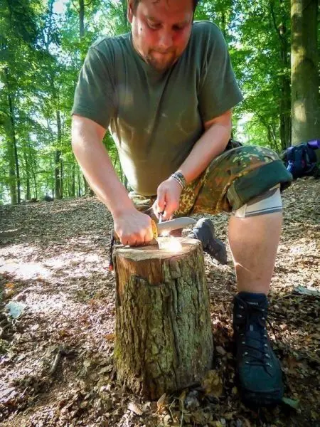 Messer schneidet Zunder auf einem Baumstumpf im Wald