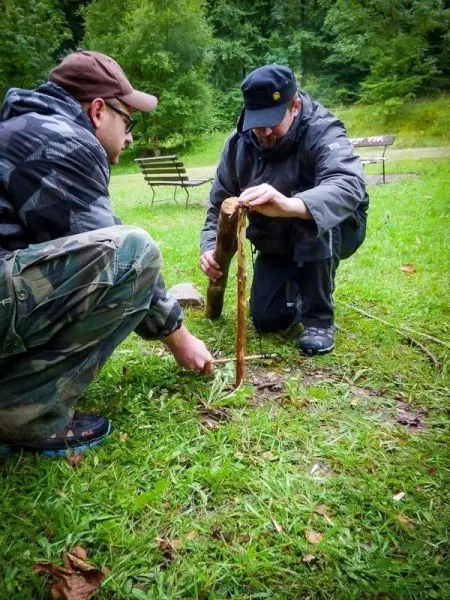 Person bearbeitet einen Stock auf dem Boden