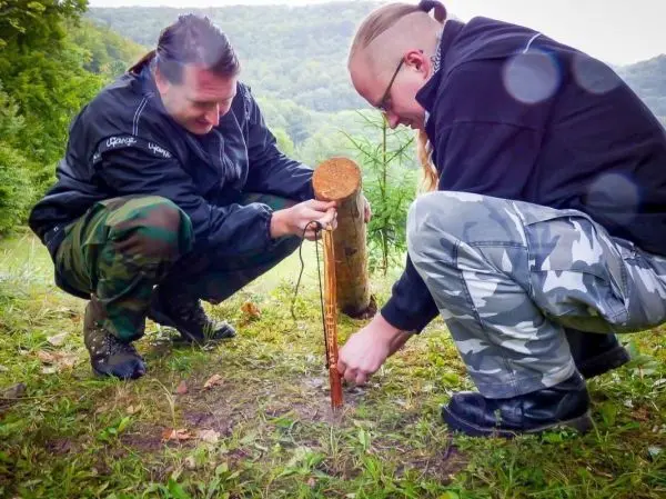 Zwei Personen befestigen einen Stock im Boden