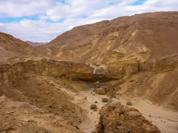 Felsige Landschaft mit Hügeln und einer Schlucht im Vordergrund