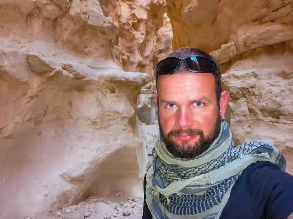 Felsige Schlucht mit einer Person in Sonnenbrille und Kopftuch