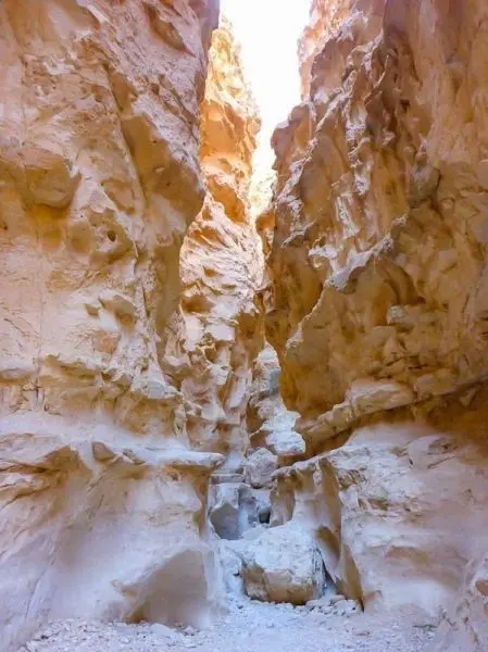 Schlucht mit steilen, sandfarbenen Felswänden und schmalem Boden