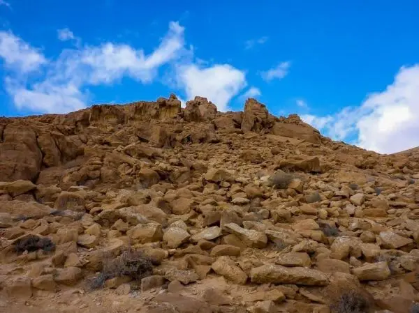 Steinige Hügel mit zerklüfteten Felsen und blauem Himmel im Hintergrund