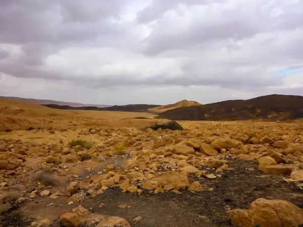 Weite, steinige Landschaft mit Hügeln und bewölktem Himmel