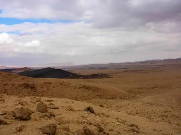 Weite, trockene Landschaft mit felsigem Untergrund und bewölktem Himmel