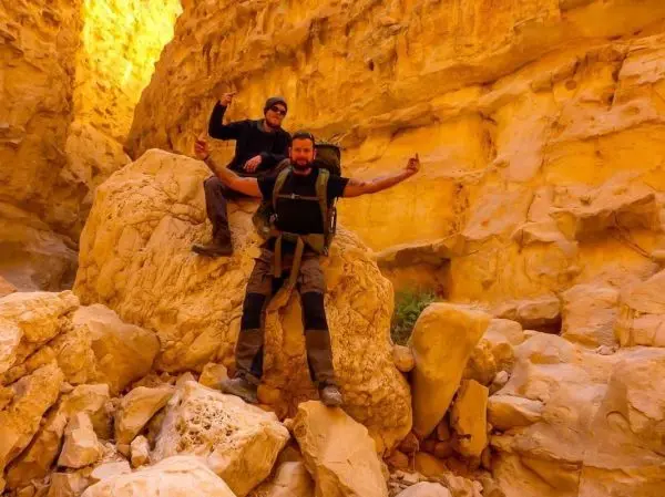 Zwei Personen posieren auf einem großen Felsen in einer Schlucht