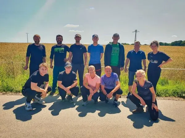 Gruppierung von Personen auf einer Straße vor einem Feld