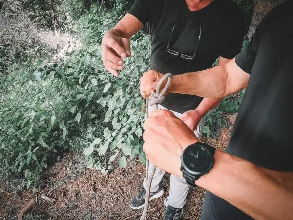 Hände binden ein Seil zu einer Schlaufe, um eine Verbindung herzustellen