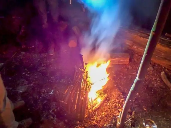 Feuer brennt in einem Lager mit Rauch und Holzstücken