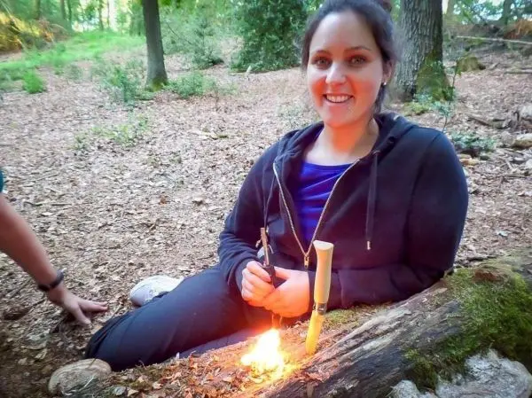 Kleine Flamme brennt auf einem Holzstück im Wald