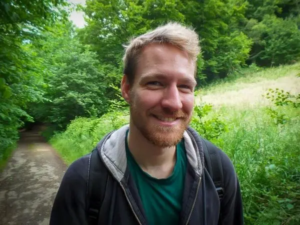 Landschaft mit Weg, umgeben von Bäumen und hohem Gras