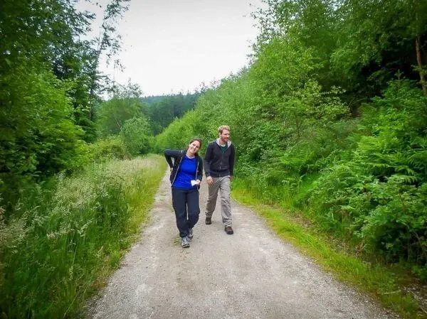 Zwei Personen gehen auf einem Schotterweg entlang