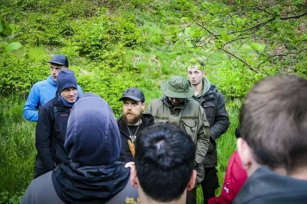 Gruppe von Personen in der Natur hört einem Vortrag zu