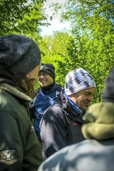 Gruppengespräch im Freien, umgeben von Bäumen und Pflanzen