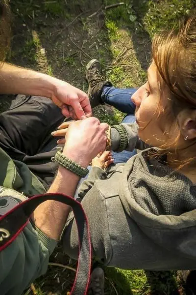 Hände binden Paracord um ein Handgelenk