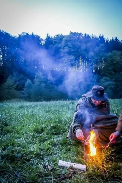 Kleine Flamme glimmt auf dem Boden, Rauch zieht auf