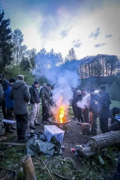 Kleine Flamme mit Rauch inmitten einer Gruppe von Personen am Boden