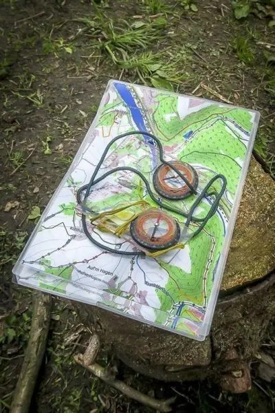 Kompasse liegen auf einer Karte auf einem Baumstumpf