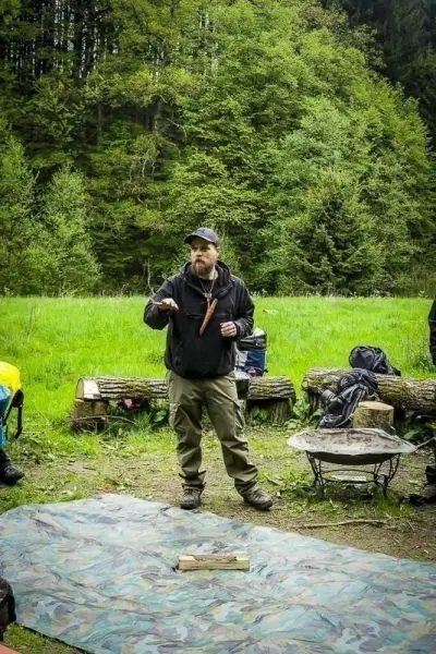 Mann erklärt Techniken auf einer Tarp-Unterlage im Freien