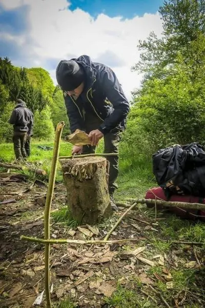 Messer bearbeitet Holzstück auf einem Baumstumpf in der Natur