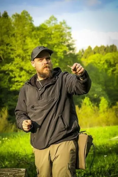 Person zeigt etwas mit der Hand im Freien