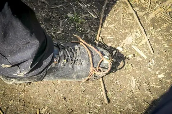 Schnürsenkel aus Rinde um einen Schuh gewickelt, auf dem Boden liegend