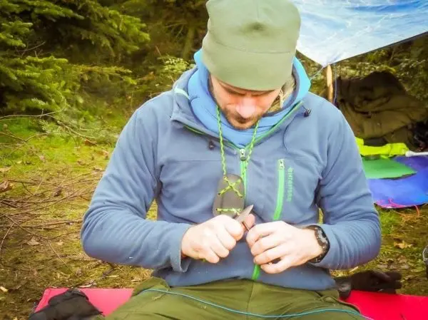 Messer bearbeitet Holzstück auf einer Unterlage im Wald