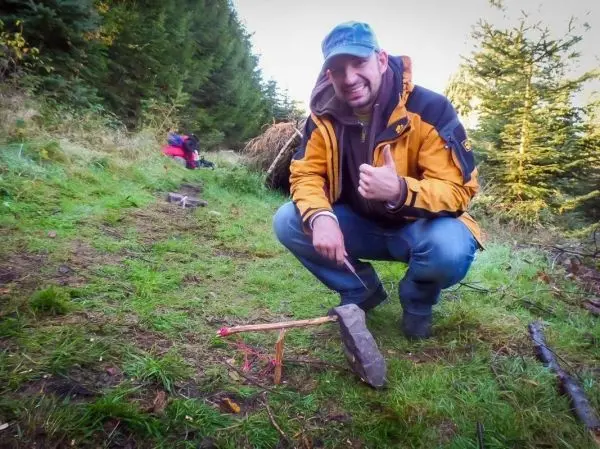 Schlagfalle (Figure-Four-Falle) mit Stein und Holzstücken auf dem Boden