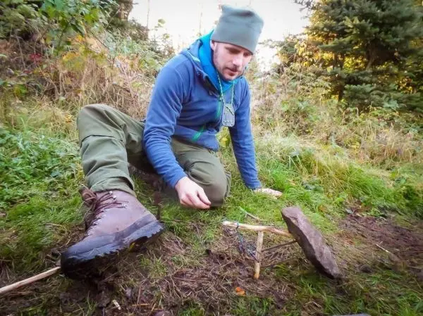 Schlagfalle (Figure-Four) wird mit einem Stock und einem Stein vorbereitet