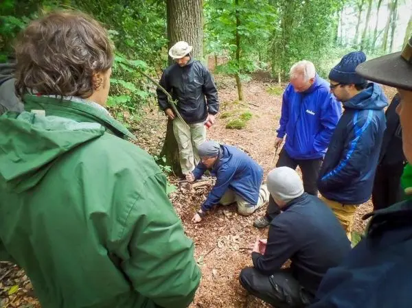 Gruppe beobachtet Anleitung zur Spurensuche im Wald