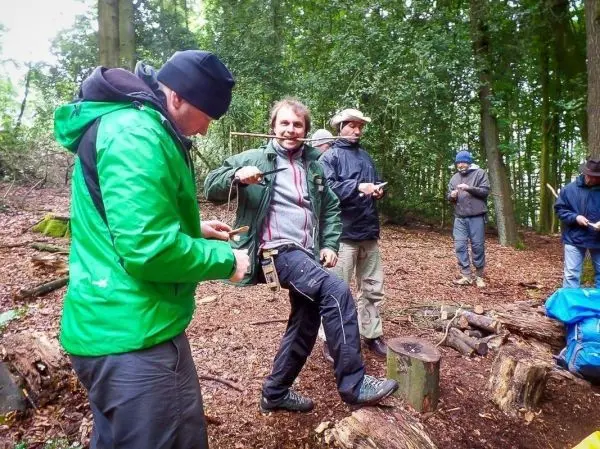 Gruppierung von Personen im Wald, einige halten Werkzeuge in den Händen