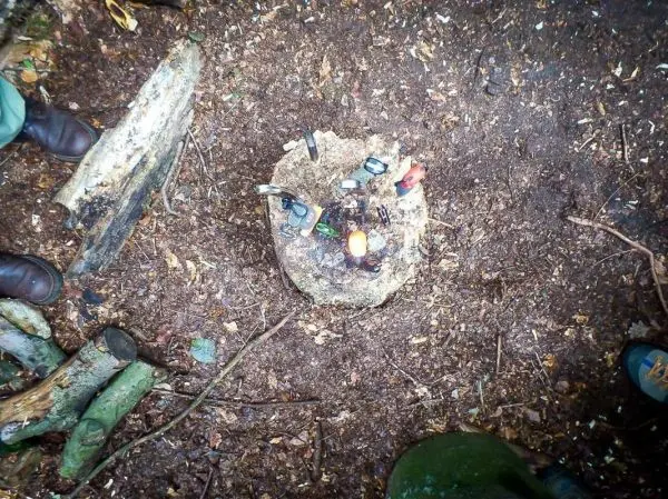 Kleine Feuerstelle auf einem Baumstumpf mit verschiedenen Werkzeugen und Zunder