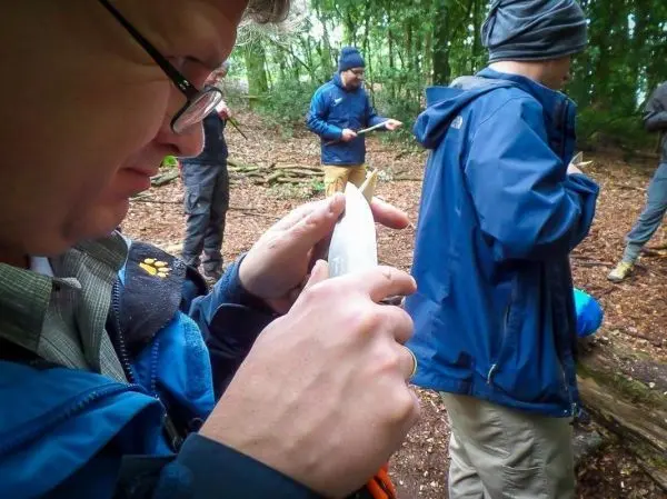 Messer schneidet Holzstück in einer Waldumgebung