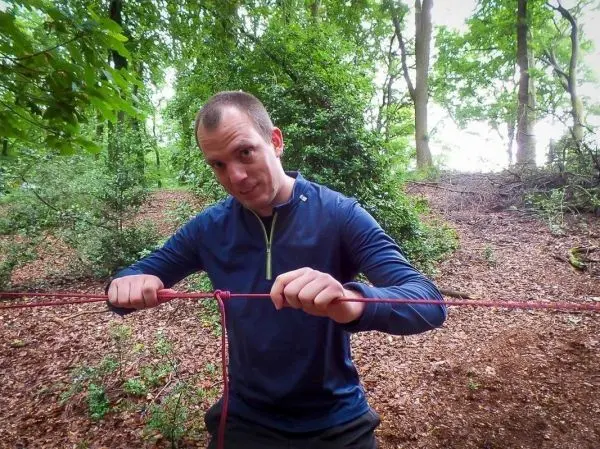 Person bindet ein Seil in der Natur