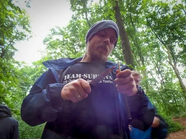 Person schnitzt mit einem Messer im Wald