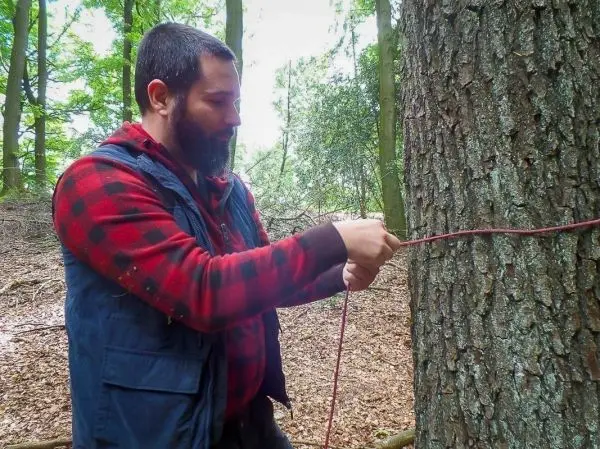 Seil wird um einen Baumstamm gewickelt und gesichert