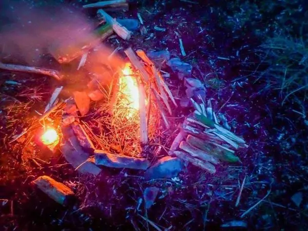 Feuerstelle mit brennendem Holz und Steinen umgeben