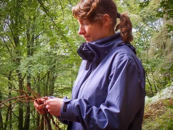 Frau knotet Äste im Wald