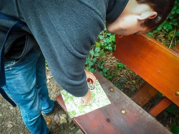 Karte liegt auf einer Bank, Kompass wird darauf ausgerichtet