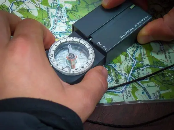 Kompass wird auf einer Karte ausgerichtet, um die Richtung zu bestimmen