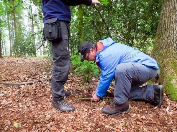 Person richtet eine Falle im Wald ein