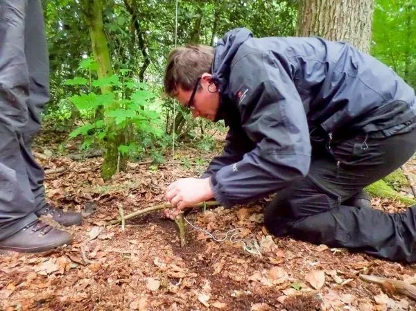 Person richtet eine Falle im Wald ein